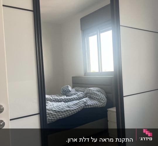 מראה בחדר שינה עם מיטה ליד חלון